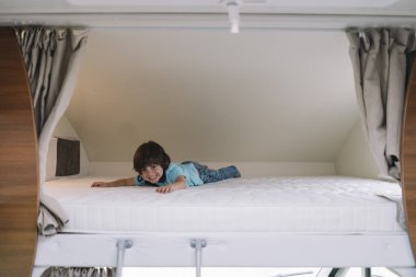 Karavan yatakta oynarken küçük çocuk