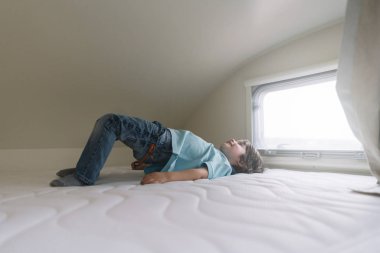 Karavan yatakta oynarken küçük çocuk