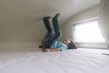 Karavan yatakta oynarken küçük çocuk