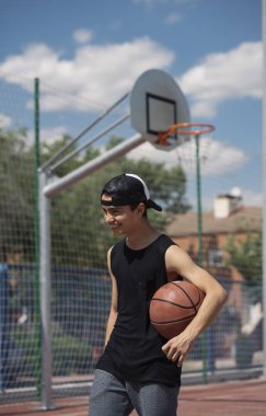 Genç adam bir basketbol topu tutan