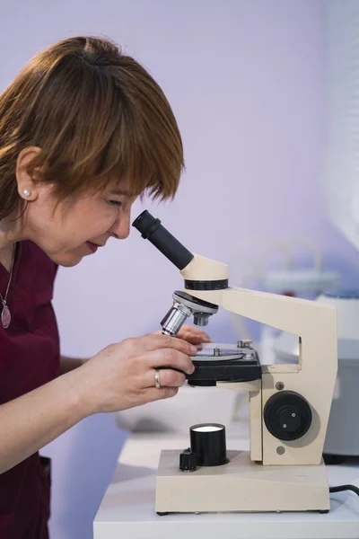 Woman with microscope, ready for use