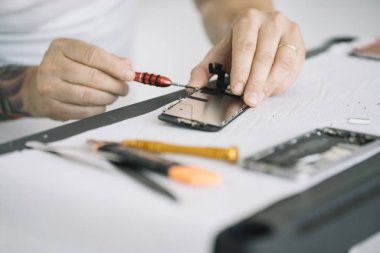 Elektronik tamir servisi. Teftiş için akıllı telefonu sökme teknisyeni.