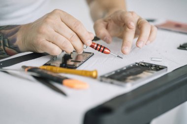 Elektronik tamir servisi. Teftiş için akıllı telefonu sökme teknisyeni.
