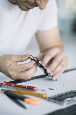 Elektronik tamir servisi. Teftiş için akıllı telefonu sökme teknisyeni.