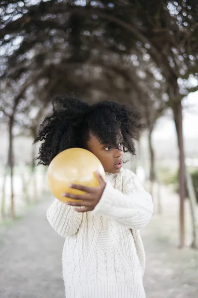 Girl blowing balloon outside