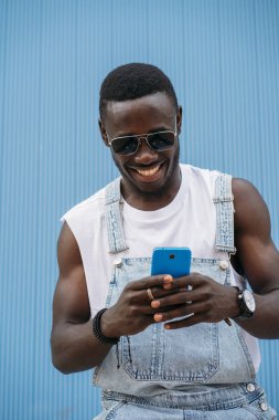 Cep telefonunu kullanan yakışıklı afro adam portresi.