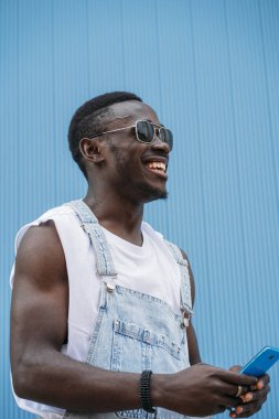 Cep telefonunu kullanan yakışıklı afro adam portresi.