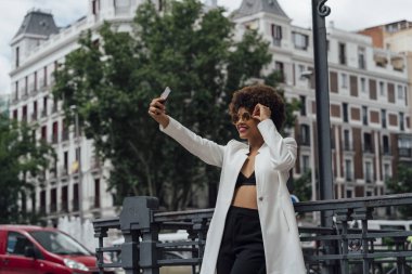 Güzel Afro saçlı kız Madrid İspanya sokaklarda cep telefonunuzla