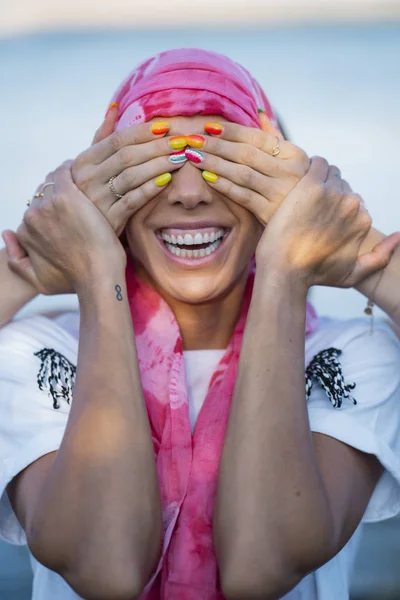 Woman with scarf pink and hands covering her eyes