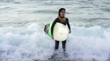 Genç kadın onun surfboard dalga sörf
