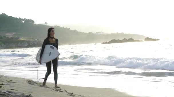 若い女性の彼のサーフボードで波をサーフィン — ストック動画