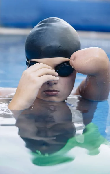 水泳は 彼無効になって 腕を欠いている少年人 水泳ゴーグルを付ける — ストック写真