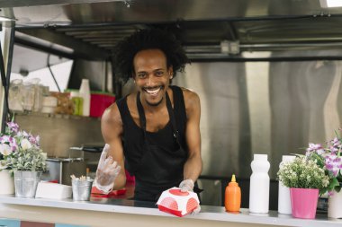 Gıda satıcı gülümseyen gıda bekleyen müşteriye eller