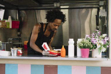 Gıda satıcı gülümseyen gıda bekleyen müşteriye eller