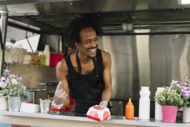 Gıda satıcı gülümseyen gıda bekleyen müşteriye eller