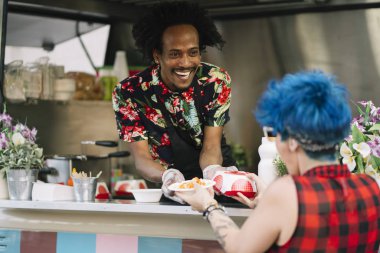 Gıda satıcı gülümseyen gıda bekleyen müşteriye eller