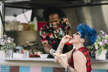 Gıda satıcı gülümseyen gıda bekleyen müşteriye eller