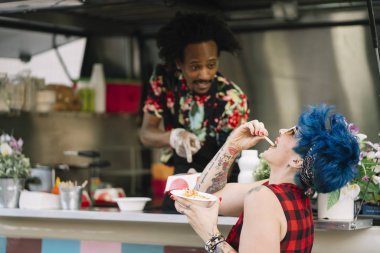 Gıda satıcı gülümseyen gıda bekleyen müşteriye eller