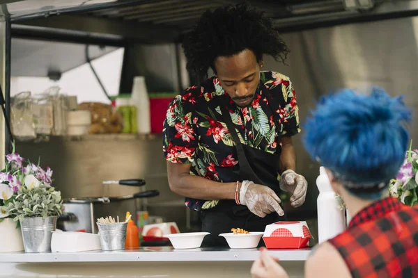 Gıda satıcı gülümseyen gıda bekleyen müşteriye eller