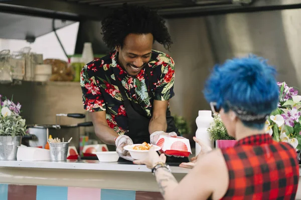 Gıda satıcı gülümseyen gıda bekleyen müşteriye eller