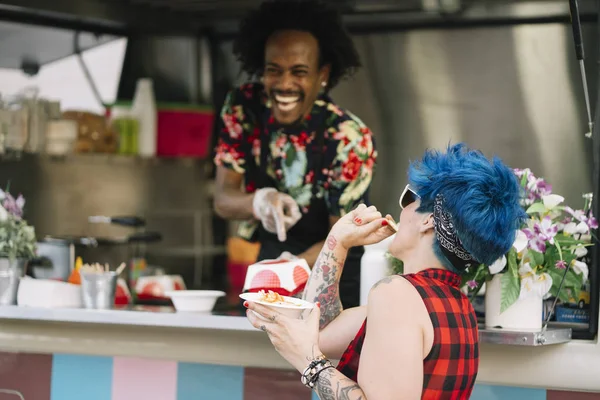 Gıda satıcı gülümseyen gıda bekleyen müşteriye eller