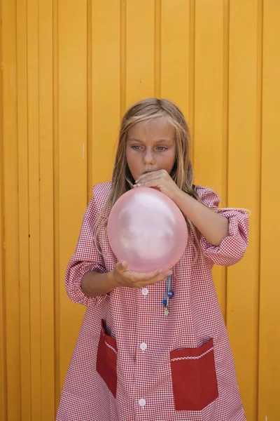 Menina Soprando Balão Fora Com Fundo Amarelo — Fotografia de Stock