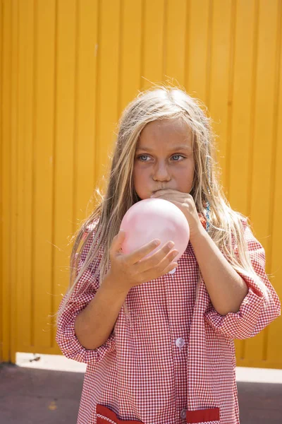 Menina Soprando Balão Fora Com Fundo Amarelo — Fotografia de Stock