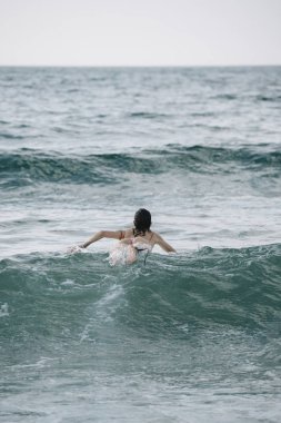 Genç kadın onun surfboard dalga sörf