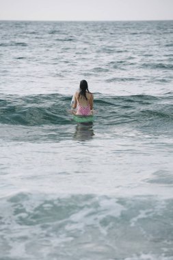 Genç kadın onun surfboard dalga sörf