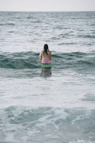 Genç kadın onun surfboard dalga sörf