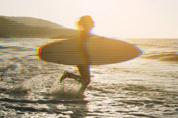 Woman with surfboard standing on wet sandy beach at the ocean. Vintage effect