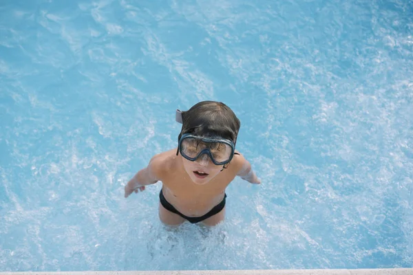 Kid playing and jumping in the pool