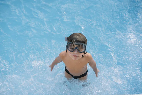 Kid playing and jumping in the pool