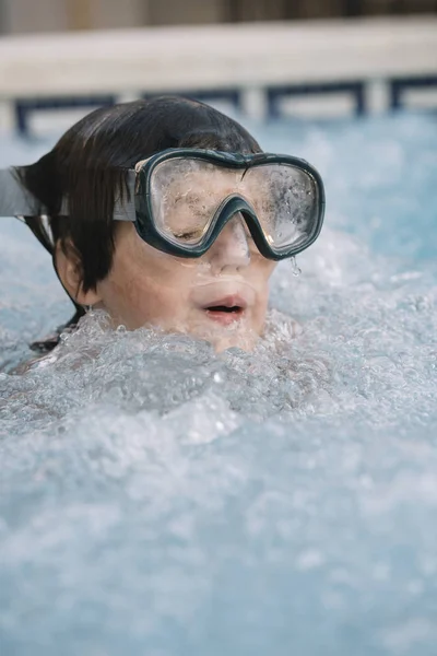 Kid playing and jumping in the pool