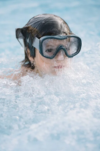 Kid playing and jumping in the pool