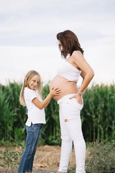 小女孩与她怀孕的母亲在领域 — 图库照片