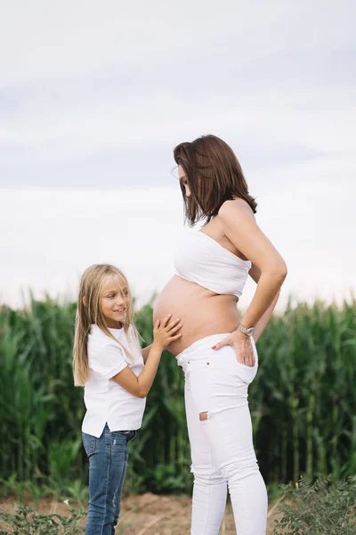 小女孩与她怀孕的母亲在领域 — 图库照片