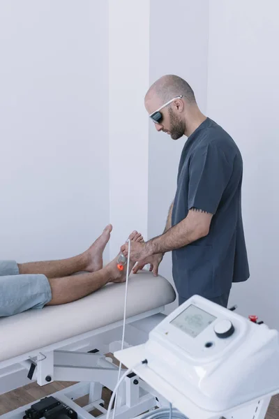 Léčení Člověka Pomocí Zařízení Pro Blesk Laser Fyzioterapeut — Stock fotografie