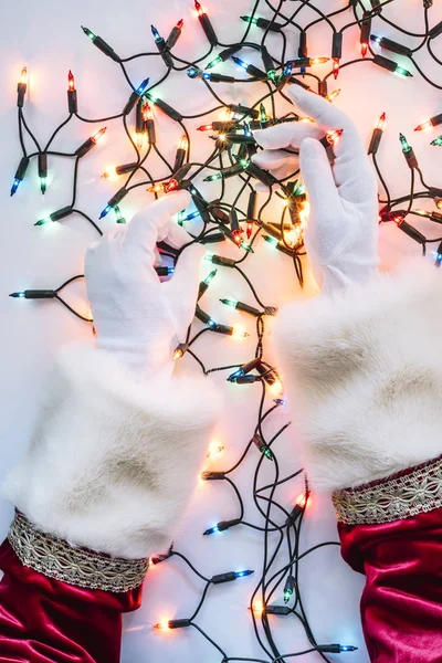 クリスマスの照明を置くことによってサンタ クロースの手 — ストック写真