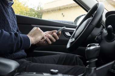 Arabada smartphone kullanan adam