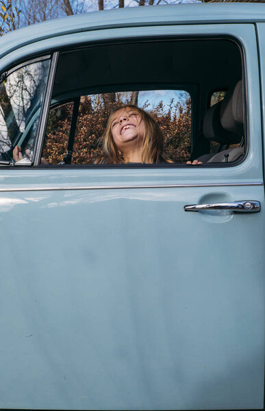 Little blonde girl in the car window