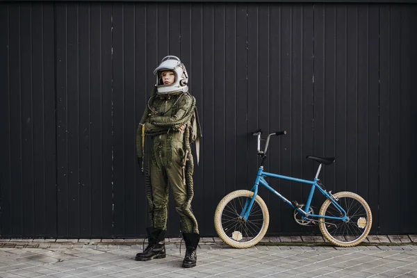 Portrait of a boy on a bicycle in street astronaut dress
