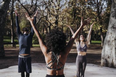 Pratik yoga parkta kişilik grup