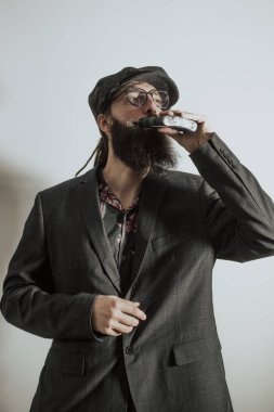 Sakal, gözlük ve şapka alkol içen adam