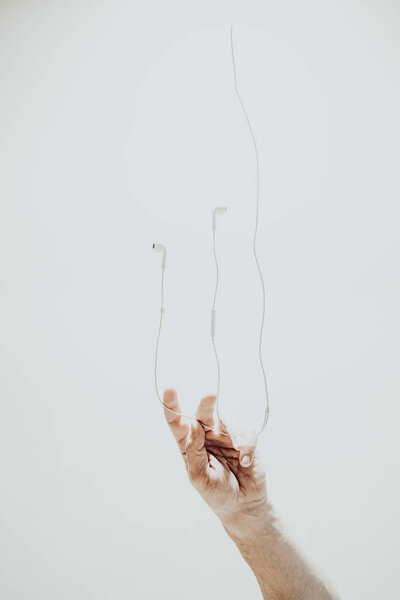 Наушники и рука на белом фоне
