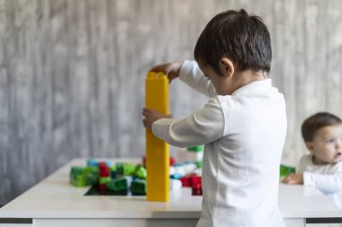 İki mutlu bebek oyuncak bloklarla oynama.