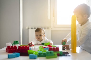 İki mutlu bebek oyuncak bloklarla oynama.