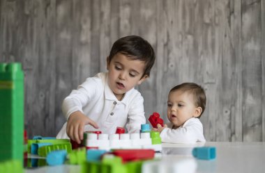 İki mutlu bebek oyuncak bloklarla oynama.