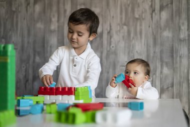 İki mutlu bebek oyuncak bloklarla oynama.