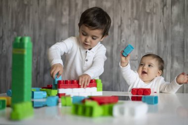 İki mutlu bebek oyuncak bloklarla oynama.